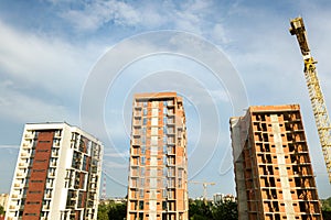 High-rise residential apartment buildings and tower crane under development on construction site. Real estate development