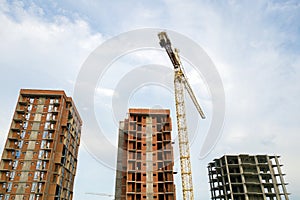 High-rise residential apartment buildings and tower crane under development on construction site. Real estate development