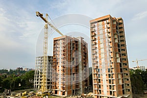 High-rise residential apartment buildings and tower crane under development on construction site. Real estate development