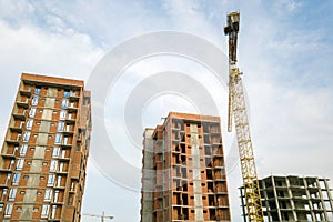 High-rise residential apartment buildings and tower crane under development on construction site. Real estate development