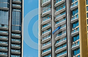 High rise window cleaner with cradle lift. Glass cleaner is working. Dangerous jobs in the building, cleaning and maintenance