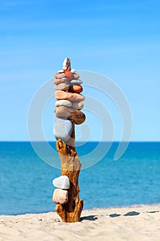 High rock zen pyramid of multi-colored stones on the background of the sea