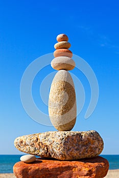 High Rock zen pyramid of white and pink pebbles on a background of blue sky and sea.