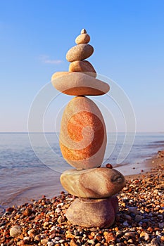 High Rock zen pyramid of white and pink pebbles on a background of blue sky and sea