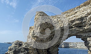 High rocks and dangerous cliffs. Azure Sea and Blue Sky