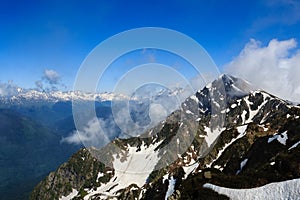 High rocky mountain peak with snow and clouds in caucasus