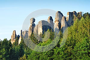 High sandstone towers rising from a forest in Adrspach