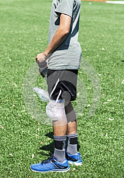 High school athlete with ice wrapped on his knee