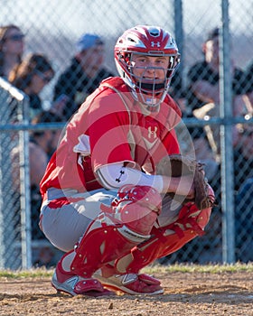 High school baseball catcher watches the dugout