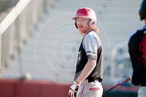 High school baseball player with long hair batting.