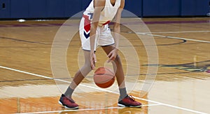 High school basketball player dribbling the ball during a game