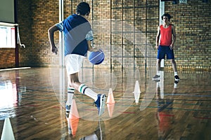 High school boys practicing football using cones for dribbling drill