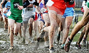 High school boys racing cross country in the mud