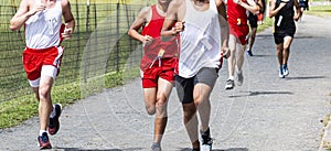 High school boys running in a cross country race on a gravel path