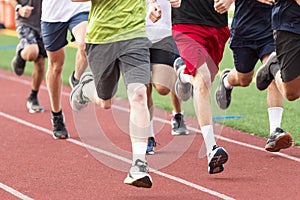 High school boys running in a group on a red track