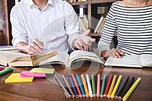 High school or college student group sitting at desk in library