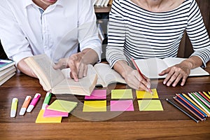 High school or college student group sitting at desk in library