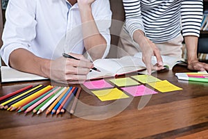 High school or college student group sitting at desk in library studying and reading, doing homework and lesson practice preparing