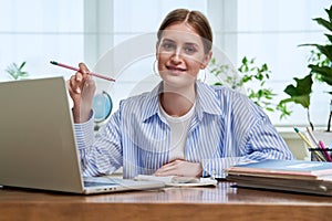 High school, college student smiling young female sitting at desk with computer