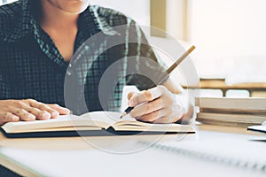 High school or college student studying and reading in library