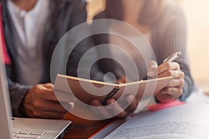 High school or college students  group catching up workbook and learning tutoring on desk and reading, doing homework, lesson