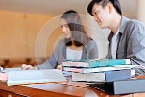 High school or college students  group catching up workbook and learning tutoring on desk and reading, doing homework, lesson