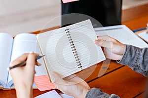 High school or college students  group catching up workbook and learning tutoring on desk and reading, doing homework, lesson