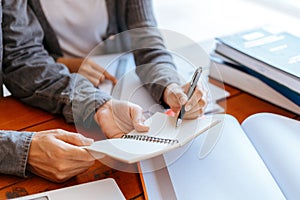 High school or college students  group catching up workbook and learning tutoring on desk and reading, doing homework, lesson