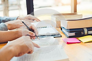 High school or college students studying and reading together in library