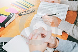 High school or college students studying and reading together in library