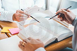 High school or college students studying and reading together in library