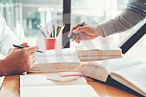 High school or college students studying and reading together in library