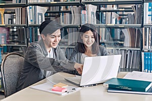 High school or college students studying and reading together in library. Student use laptop at library