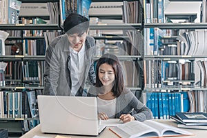 High school or college students studying and reading together in library. Student use laptop at library