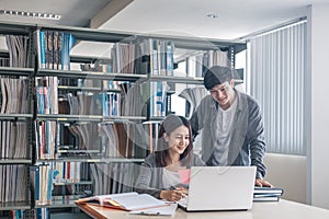 High school or college students studying and reading together in library. Student use laptop at library