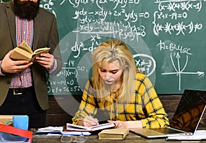 High school or college students studying and reading together in library. Trying student is the one that has the most