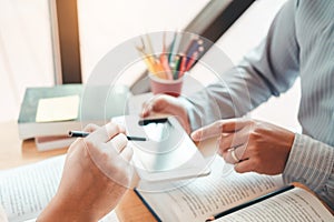 High school or college students studying and reading using tablet together in library