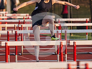 High school female running in a hurdles race