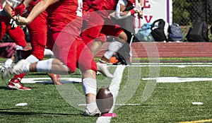 High school football kicker kicking off during a game