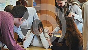 A high school girl cries and her friends comfort her. photo