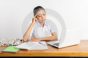 high school girl at desk in thinking pose using laptop