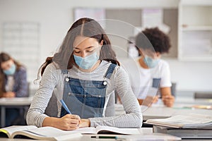 High school girl studying in class with face mask