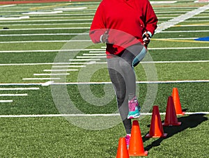 High school girls doing speed drills over orange cones