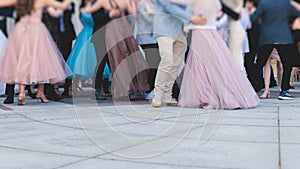 High school graduates dancing waltz and classical ball dance in dresses and suits on school prom graduation, classical ballroom