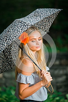 High school senior poses with umbrella for portraits on a rainy