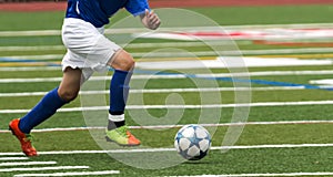 High School soccer player running with the ball