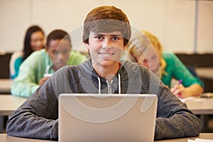 High School Student At Desk In Class Using Digital Tablet