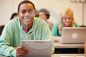 High School Student At Desk In Class Using Digital Tablet