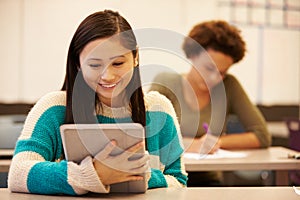 High School Student At Desk In Class Using Digital Tablet
