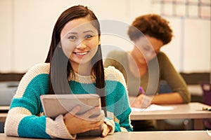 High School Student At Desk In Class Using Digital Tablet